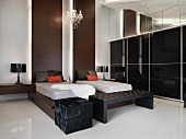 Designer Schlafraum - Einzelbetten auf dunklem Holzgestell und Holzpanelen an Wand neben Schrankwand mit schwarzen Glasschiebetüren