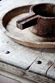 Old metal jug on wooden plate and table made from weathered wooden boards