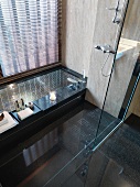 View of sunken bathtub through glass wall