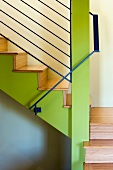 Holztreppe mit grüner Treppenwand