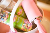 Pink rolling pin in a basket with sprinkles close up