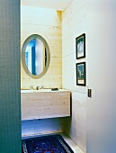 Bathroom with stone-tiled walls, stone washstand and oval mirror