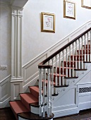 Georgian staircase with gilt-framed botanical pictures on wall