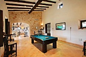 Wooden ceiling beams and pool table in Spanish style home