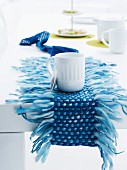 Small, woven, mottled blue table runner with long, irregular fringed edges