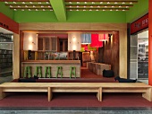 Bar und Lounge mit kleinen Holztischen und großen bunten Lampen