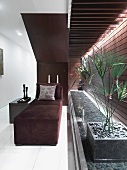 Modern velvet lounge chair near indoor water feature