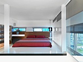 Doppelbett mit roter glänzender Tagesdecke in elegantem Schlafzimmer