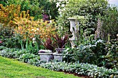 Decorative planters in densely planted herbaceous border
