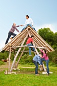 People climbing log hut outdoors