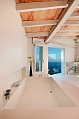 Designer Badewanne unter moderner Holzdecke