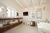 Waschtischzeile und Unterschrank im designten Bad mit weiss getünchter Holzbalkendecke