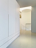 White wardrobe in a modern lobby and a view of a staircase