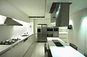 weiße Designerküche mit Essplatz unter Dunstabzug