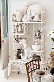 Collection of sculptures and teapots on white, vintage shelving