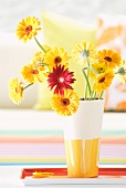 Gerbera daisies in white and yellow ceramic vase