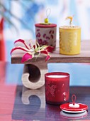 Tealights in coloured, patterned glass holders with decorated lids