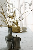 Branches with flowers and feathers decorating a vintage vase