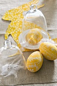 Easter eggs decorated in yellow and white, cheese cover and bunny rabbit decoration made of construction paper