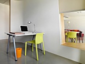 Moderner Arbeitsplatz neben Raumteiler mit offenem Ausschnitt und Blick auf den Esstisch