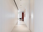 Narrow hallway with suspended ceiling and white lacquer wood wall paneling