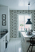 Scandinavian-style kitchen with patterned wallpaper and pendant light
