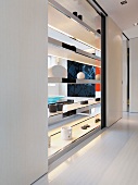Schiebetüren vor transparentem Regal als Raumteiler in offenem Wohnraum