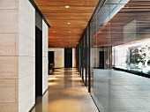 Two lobby areas separated by a wall of glass formed by sliding doors with a view of water pools