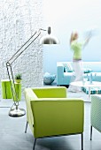 Interior in shades of aquamarine with green armchair & stainless lamp