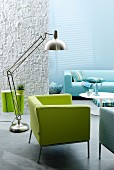 Interior in shades of aquamarine; green armchair, stainless steel designer lamp and blue sofa in background