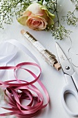 Ribbon, wire, scissors and a rose