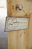 Door sign hanging on knob of rustic, interior wooden door