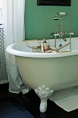 Badezimmer mit freistehender Badewanne und grüner Wand