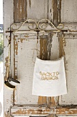 Linen sack and soup ladles hanging on weathered window shutter