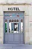 Mirrored entrance door to a hotel with a historic stone facade