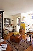 Offener Wohnraum und Küchennische mit gesammelten Vintage-Möbeln verschiedener Stilrichtungen auf Landhausdielen