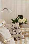 Cotton cushion cover made from linen grain sacks with german text on a beige and white gingham sofa