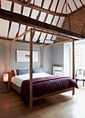 Minimalist canopy bed in modern bedroom with rustic, half-timbered ceiling