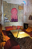 Wohnecke im orientalischen Stil mit Tischlampe auf dem Holztisch und Steinmosaikfußboden