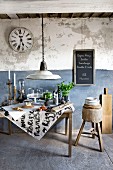 Food and kitchen utensils under glass covers on vintage table against rustic, blue and white wall