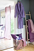Open garden door with fluttering curtain in sunny room with lilac and violet accents