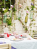 Flower arrangements hung above set terrace table