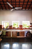 Küchenzeile mit gemauerter Arbeitsplatte am Fenster und Unterschränke