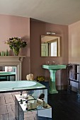 Englisches Bad mit grünem Standwaschbecken und verschiedenen Spiegelelemente zu blassbraun getönter Wand