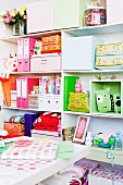 Colourful stationary and storage boxes on white shelving