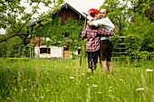 Paar umarmt sich vor einem Bauernhaus