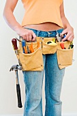 A woman wearing a toolbelt