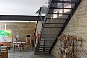 Metal staircase in bright studio with concrete walls