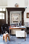 Desk below vintage tiled picture with frame and wooden surround in renovated country house