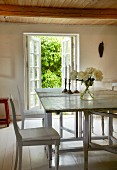 White wooden table and chairs in dining room with white wooden floor